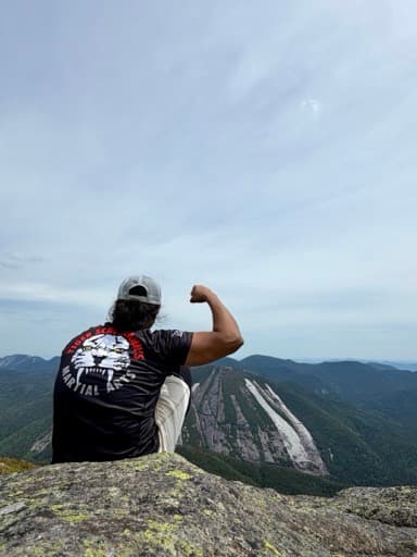 Zann sitting on a mountain overlook after a hike